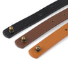 A black and tan adjustable PU leather crossbody strap with brass hardware shown diagonally.