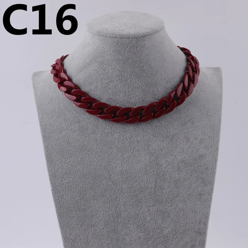A close-up of a dark red acrylic link chain necklace displayed on a mannequin neck.