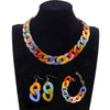 A colorful acrylic link chain necklace displayed on a black display stand.