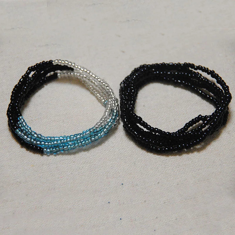 Two strands of colorful belly bead chains, featuring black and iridescent blue beads.