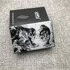A black and white illustration of a tiger and a wild cat on a cigarette case.