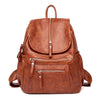 A brown vintage soft leather backpack with a top handle and zippered compartments.