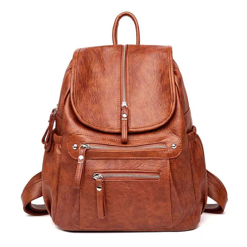 A brown vintage soft leather backpack with a top handle and zippered compartments.