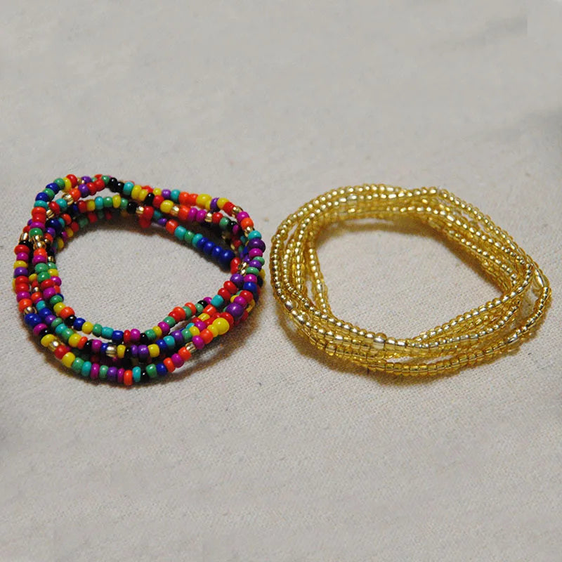 Two bracelets made of colorful belly bead chains, one multi-colored and one gold.