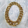 A chunky gold acrylic Cuban link necklace for men displayed against a white background.