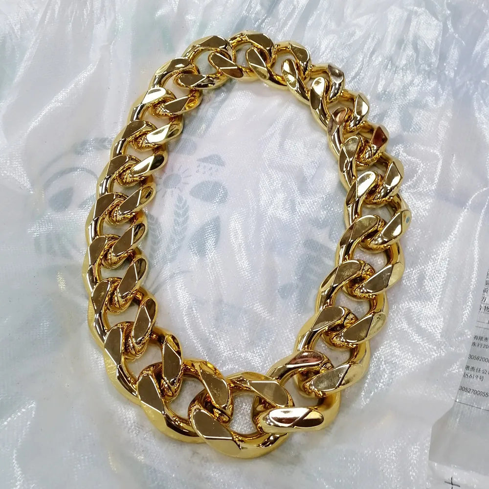 A chunky gold acrylic Cuban link necklace for men displayed against a white background.