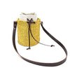 A yellow woven straw pouch with a white cloth insert and a brown leather adjustable crossbody strap.
