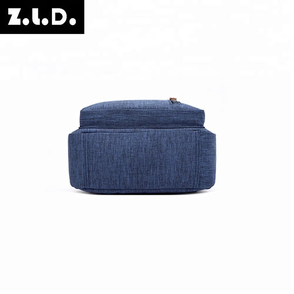 A dark blue canvas backpack with a top zipper visible.