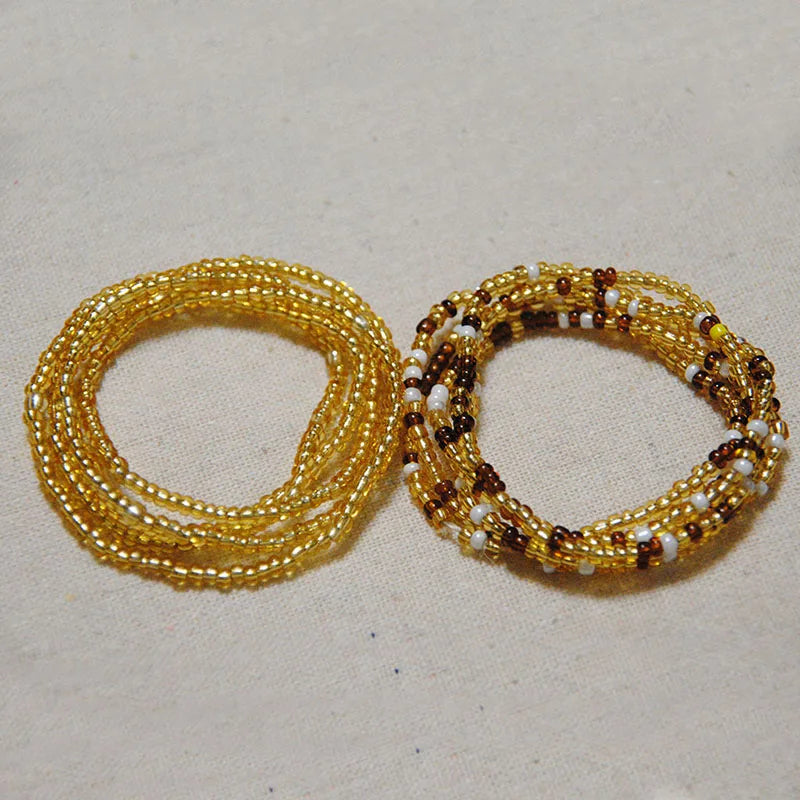 Two strands of colorful belly bead chains, featuring gold and brown beads with white accents.