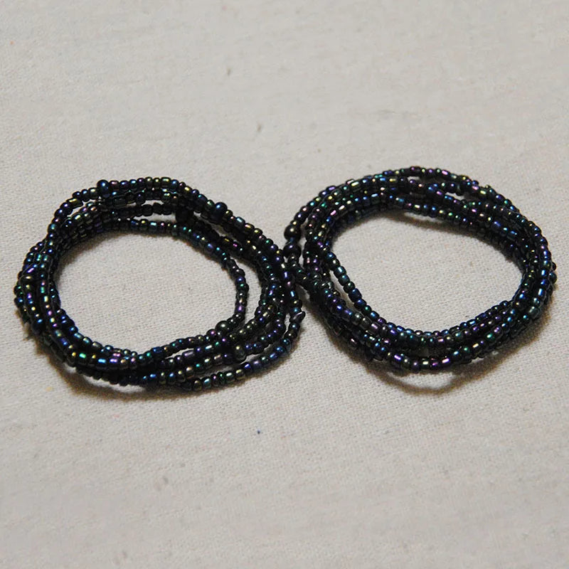 A pair of dark blue and black belly bead chains for body jewelry
