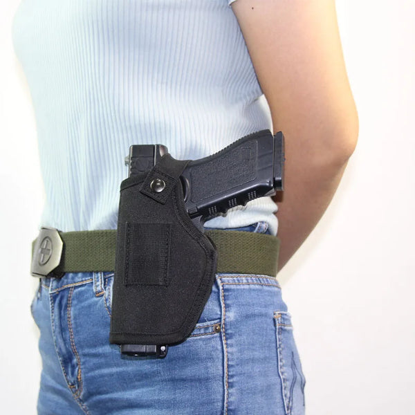 A black universal IWB concealment holster with a metal belt clip worn on a person's waist.