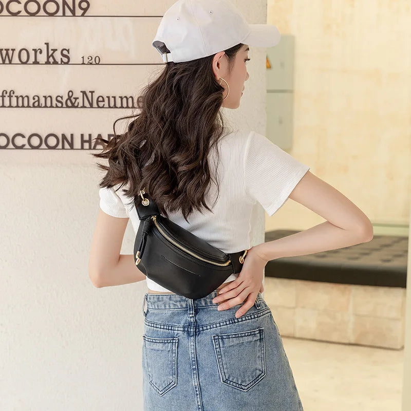 A woman wearing a white cap and white shirt holds a black PU leather crossbody sling bag.