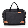 A dark gray canvas crossbody messenger bag with black straps and tan accents.