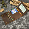 A brown leather trifold wallet with a detachable chain is shown open on a gray textured surface.