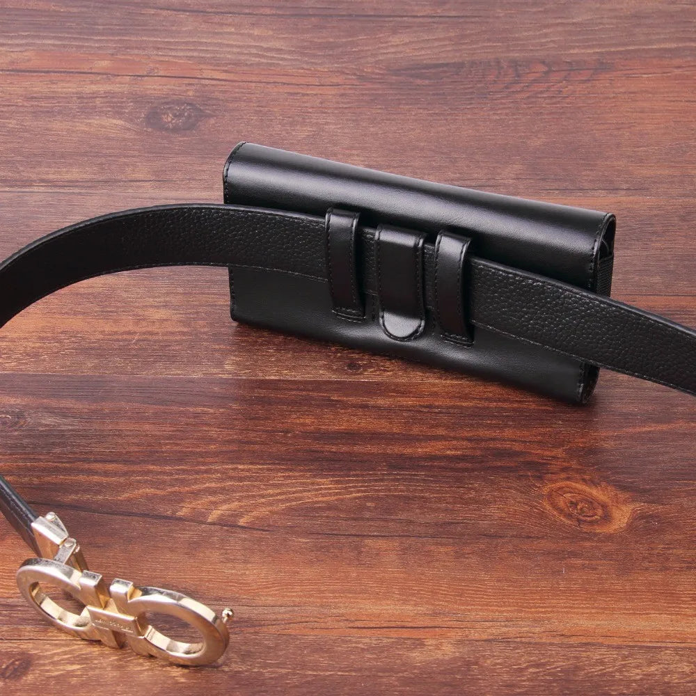 Porte-clés pour téléphone en cuir noir posé sur une surface en bois foncé.