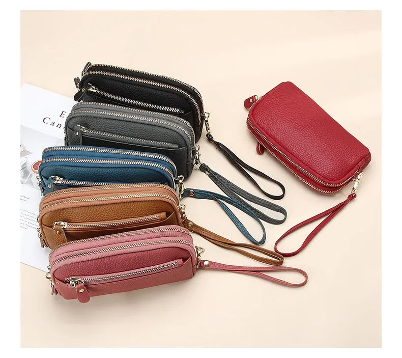 A collection of genuine cowhide leather double-zip wristlet wallets in various shades of black, blue, brown, and pink.