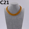 A gold-colored acrylic link chain necklace displayed on a mannequin neck.