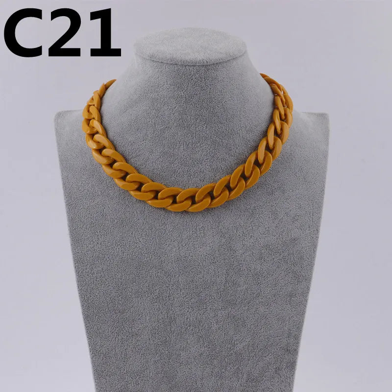 A gold-colored acrylic link chain necklace displayed on a mannequin neck.