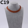 A close-up of a copper-colored acrylic link chain necklace displayed on a mannequin neck.