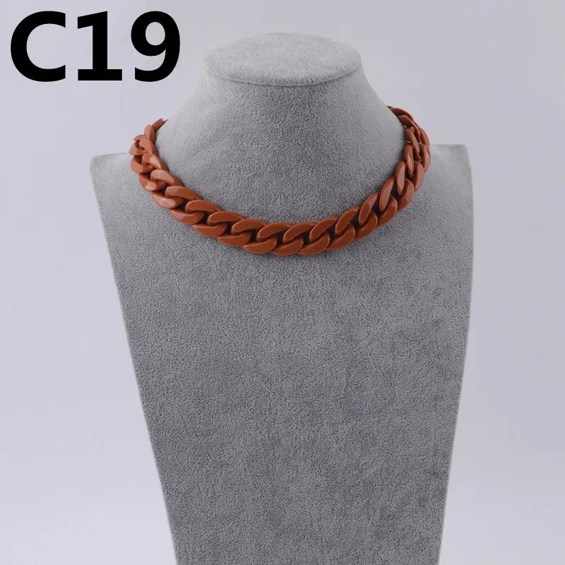 A close-up of a copper-colored acrylic link chain necklace displayed on a mannequin neck.