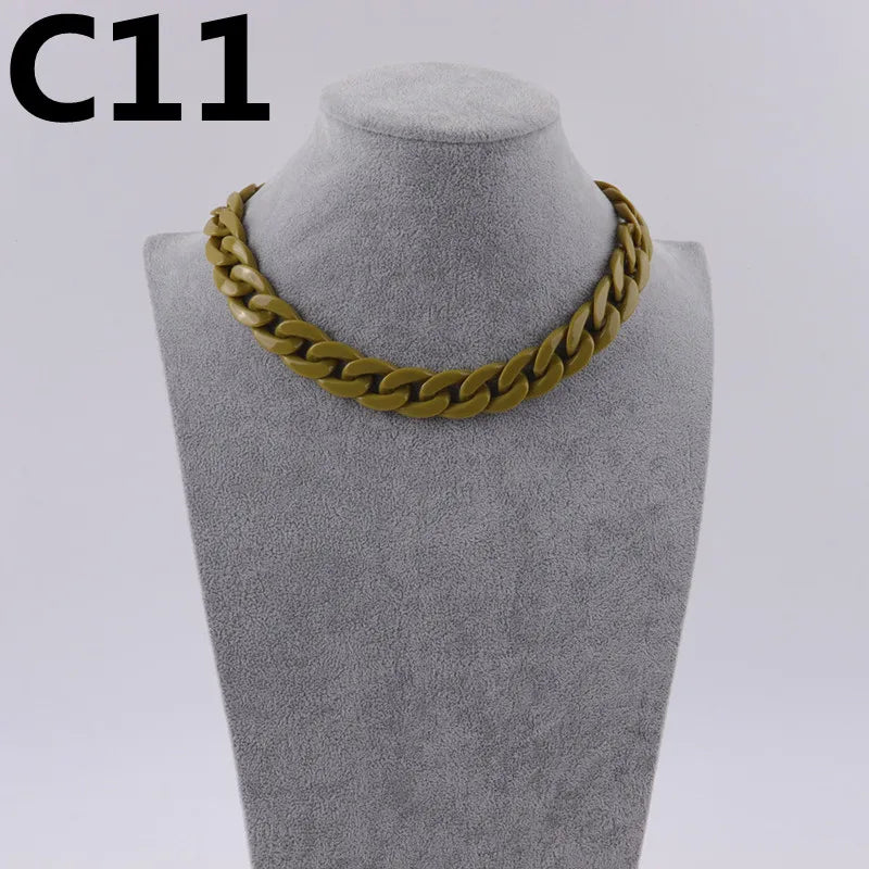 A gold-colored acrylic link chain necklace displayed on a mannequin neck.