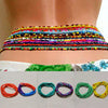 Colorful belly bead chains for body jewelry displayed on a person's abdomen.