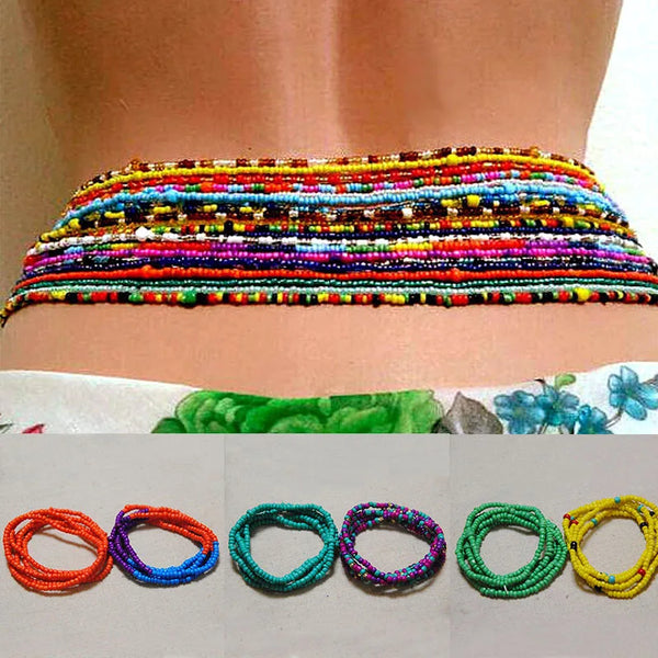 Colorful belly bead chains for body jewelry displayed on a person's abdomen.