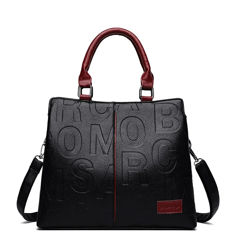 Sac bandoulière en cuir PU noir avec garniture rouge et poignées en cuir.