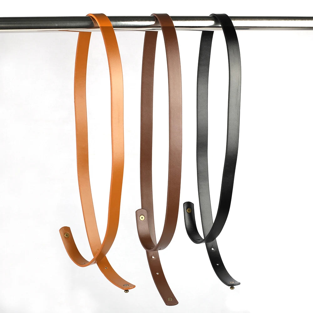 Three adjustable PU leather crossbody straps in brown, tan, and black hanging from a metal rod.