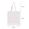White canvas tote bag with a ghost and pumpkin print, shown from the side.