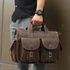A brown genuine cowhide leather briefcase carried by a person, shown from the front.