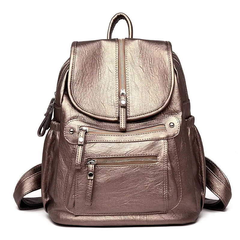 A brown vintage soft leather backpack with a flap and zippered pockets.
