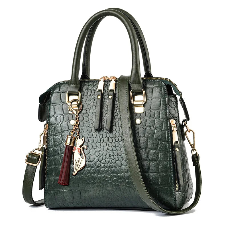 A dark green crocodile-embossed leather tassel shoulder bag with gold hardware.