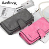 A gray and pink leather card holder wallet set with a perfume bottle and pearl necklace.