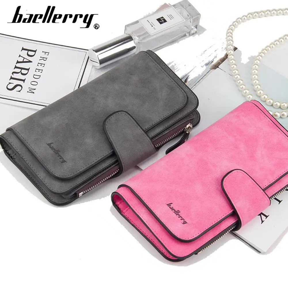 A gray and pink leather card holder wallet set with a perfume bottle and pearl necklace.