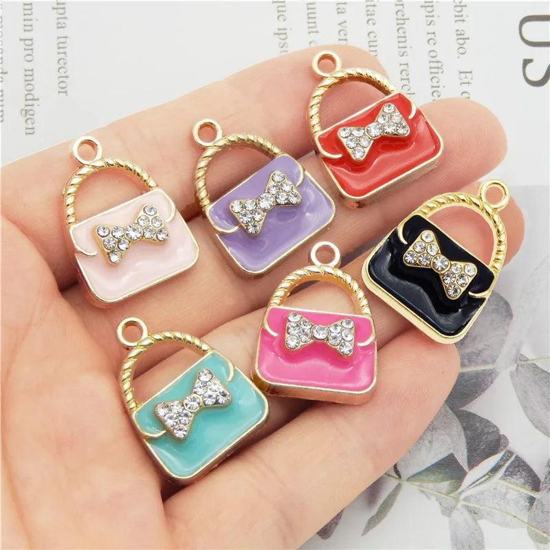 Un ensemble de six charms en alliage émail de cristal aux couleurs et designs variés, présentés sur une main.
