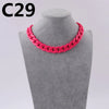 A close-up of a bright pink acrylic link chain necklace displayed on a gray mannequin neck.