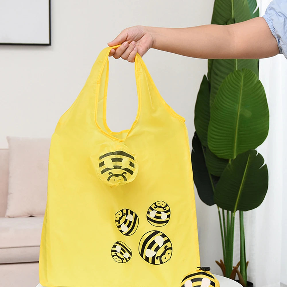 Sac de shopping jaune vif, pliable et écologique, avec des motifs de tigre noir rayé, tenu par une main.