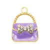 Pendentif doré avec un charm de sac en émail violet décoré de cristaux clairs.