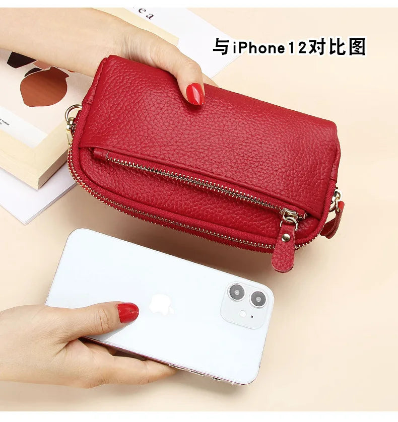 A red genuine cowhide leather double-zip wristlet wallet is shown next to an iPhone 12 for comparison.