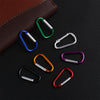 A collection of colorful aluminum carabiner hooks arranged on a dark surface.