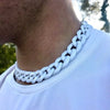 A close-up of a white braided acrylic link chain necklace worn around the neck against a white t-shirt.