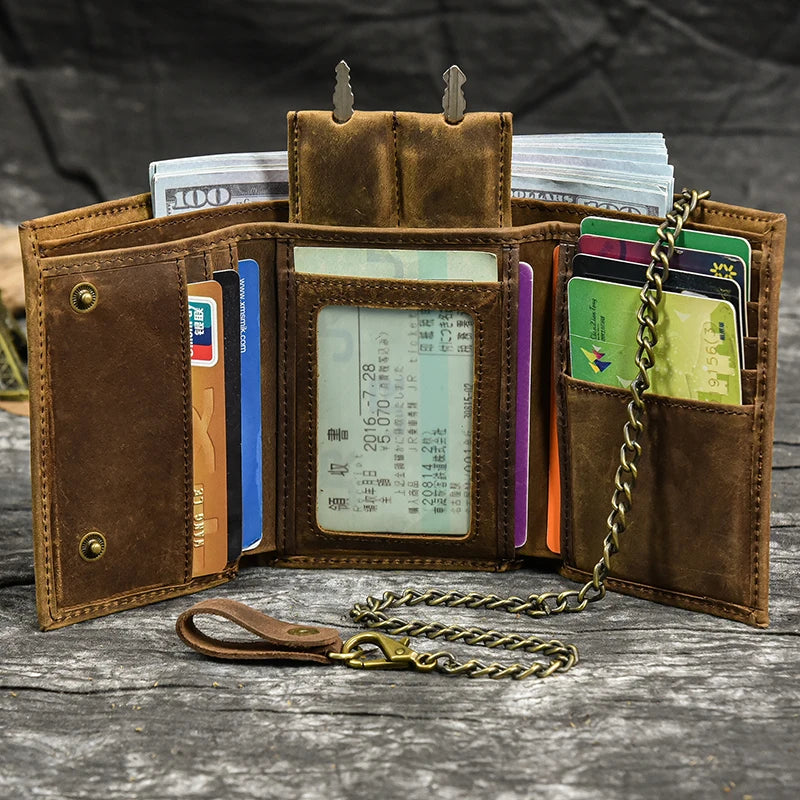 A brown leather trifold wallet with a detachable gold chain, holding cash and cards.
