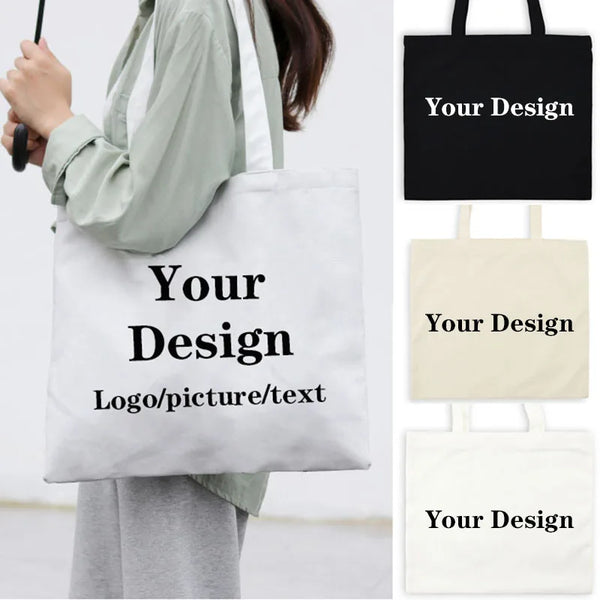 Eine Person hält eine weiße Leinencoffertasche mit schwarzem Text und demonstriert das Produkt.