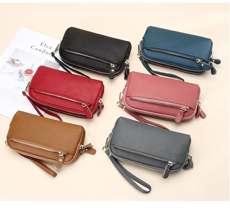 A collection of genuine cowhide leather double-zip wristlet wallets in various colors including black, navy blue, red, and br