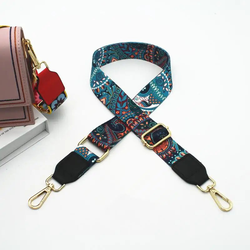 Gros plan d'un sac bandoulière réglable avec une sangle d'épaule, tissu bleu et sarcelle à motifs et accents noirs.