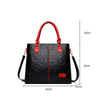 Sac à main en cuir PU noir avec poignées rouges et accents dorés, vue de face.