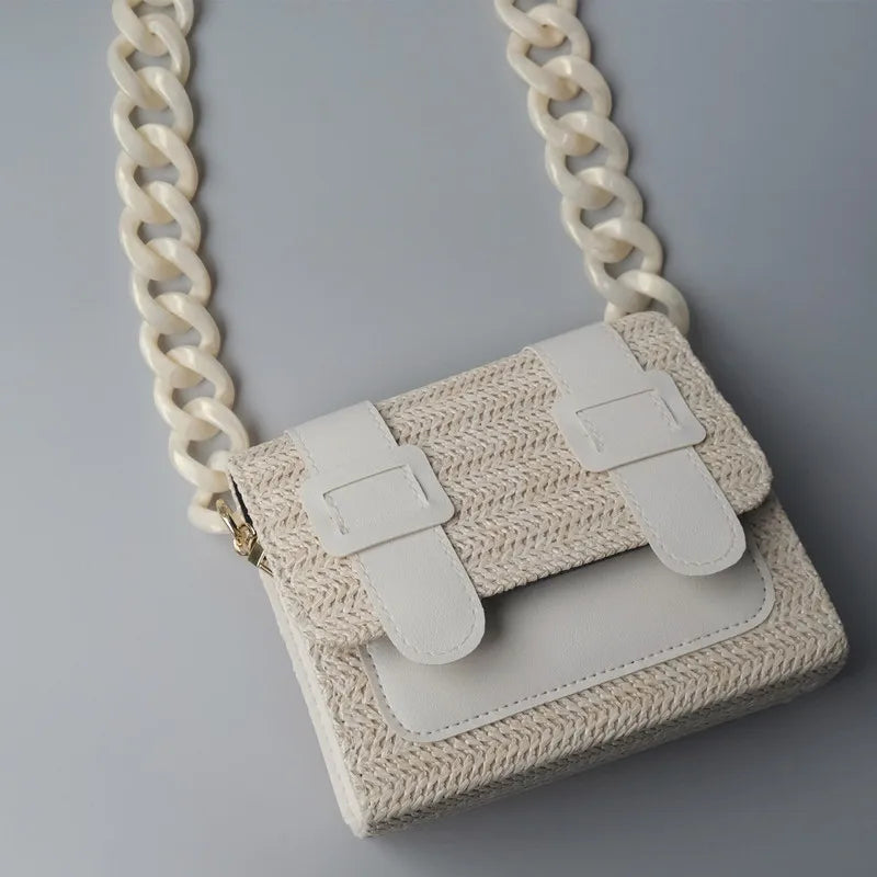 Bolso de cadena de hombro de resina beige con detalles de cuero blanco y una gruesa correa de cadena blanca.