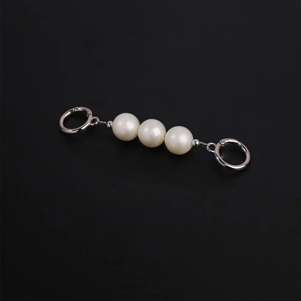 Collier argenté avec une chaîne et trois perles blanches rondes avec anneaux à saut.
