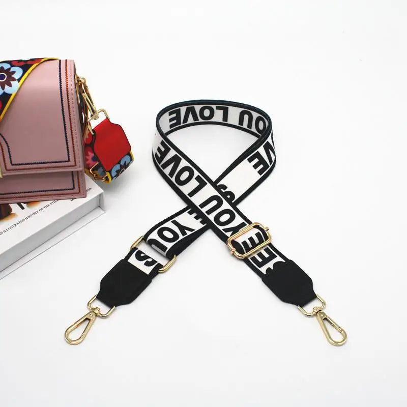 Sac bandoulière ajustable rose et noir avec motif noir et blanc.
